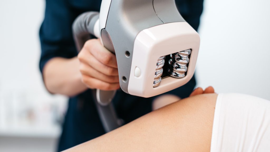 Close-up of a therapist using an ultrasound device for body contouring.